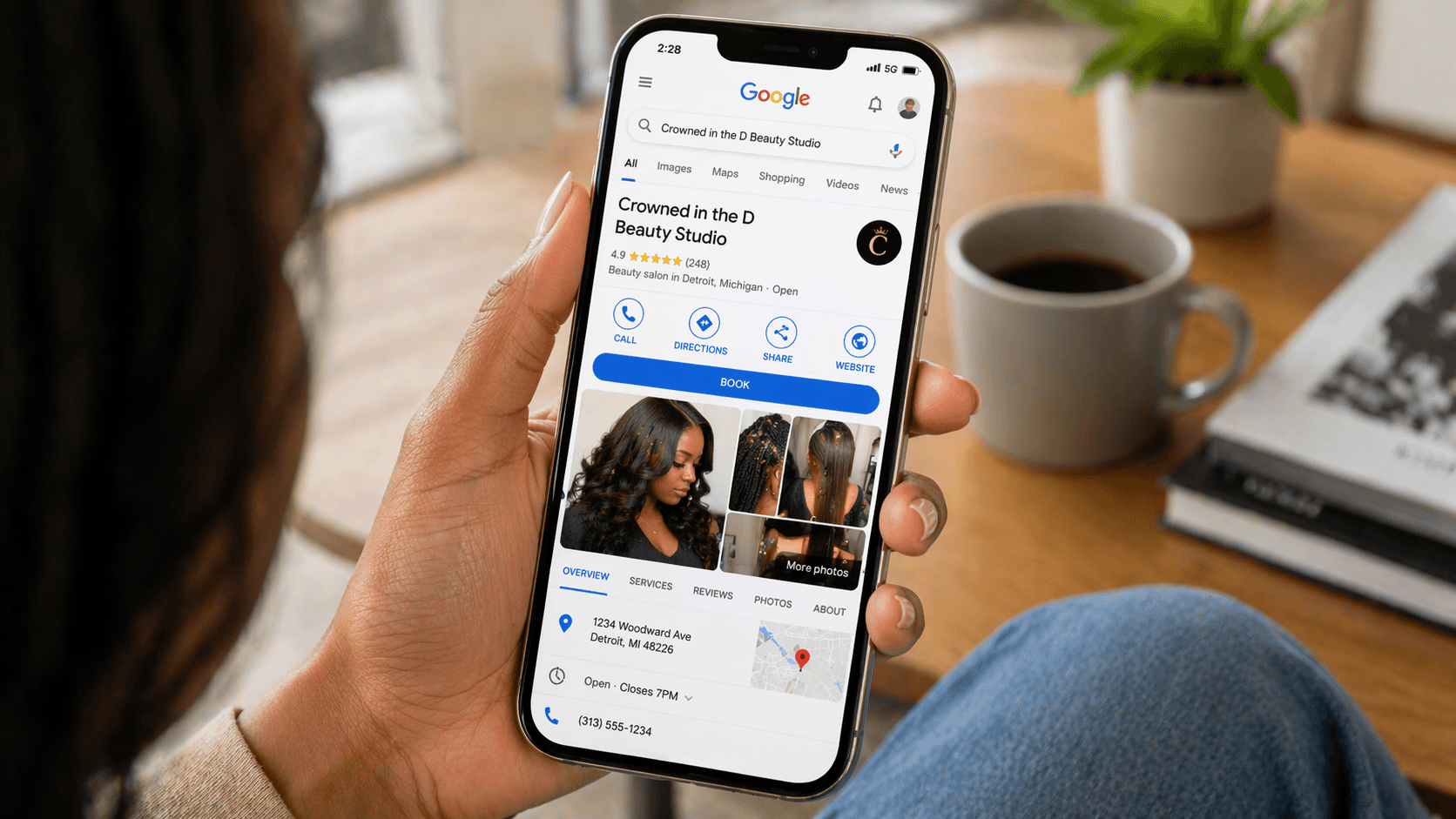 Busy modern Detroit hair salon interior with a Black female stylist working on a client’s natural hair, warm lighting and professional styling stations