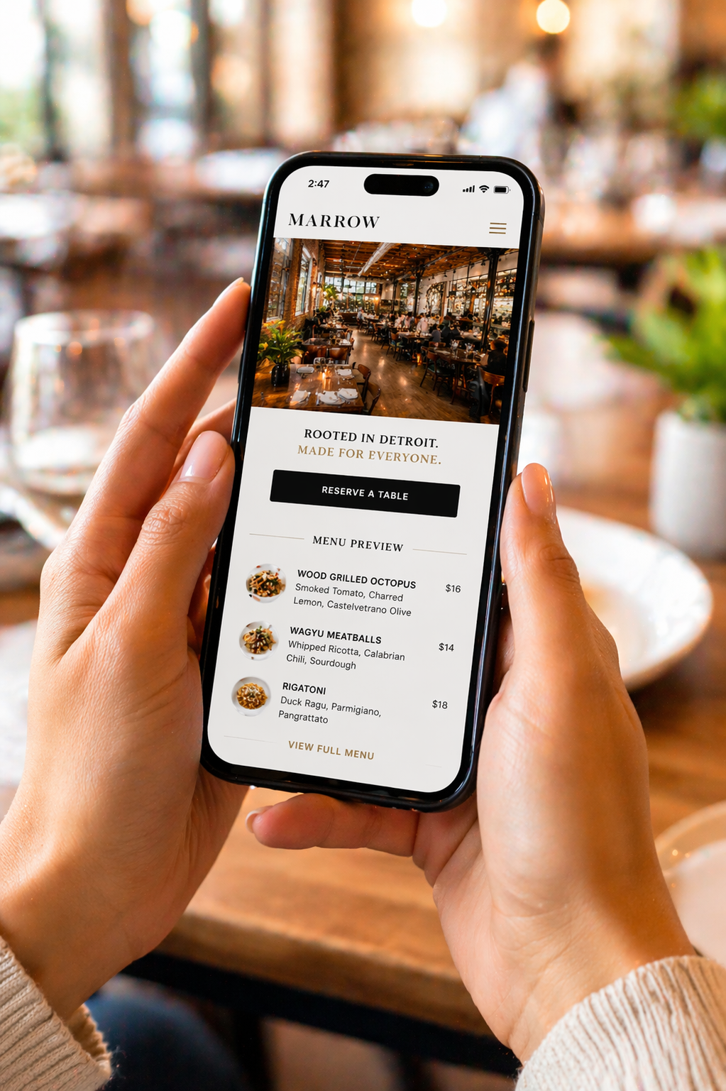 Person holding smartphone showing restaurant website with visible menu and reservation button